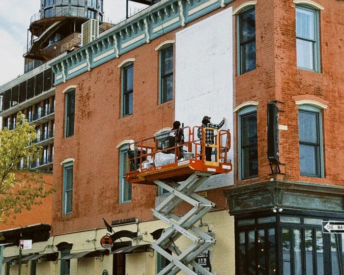 Plataforma tipo tijera elevada para trabajos en la fachada de un edificio